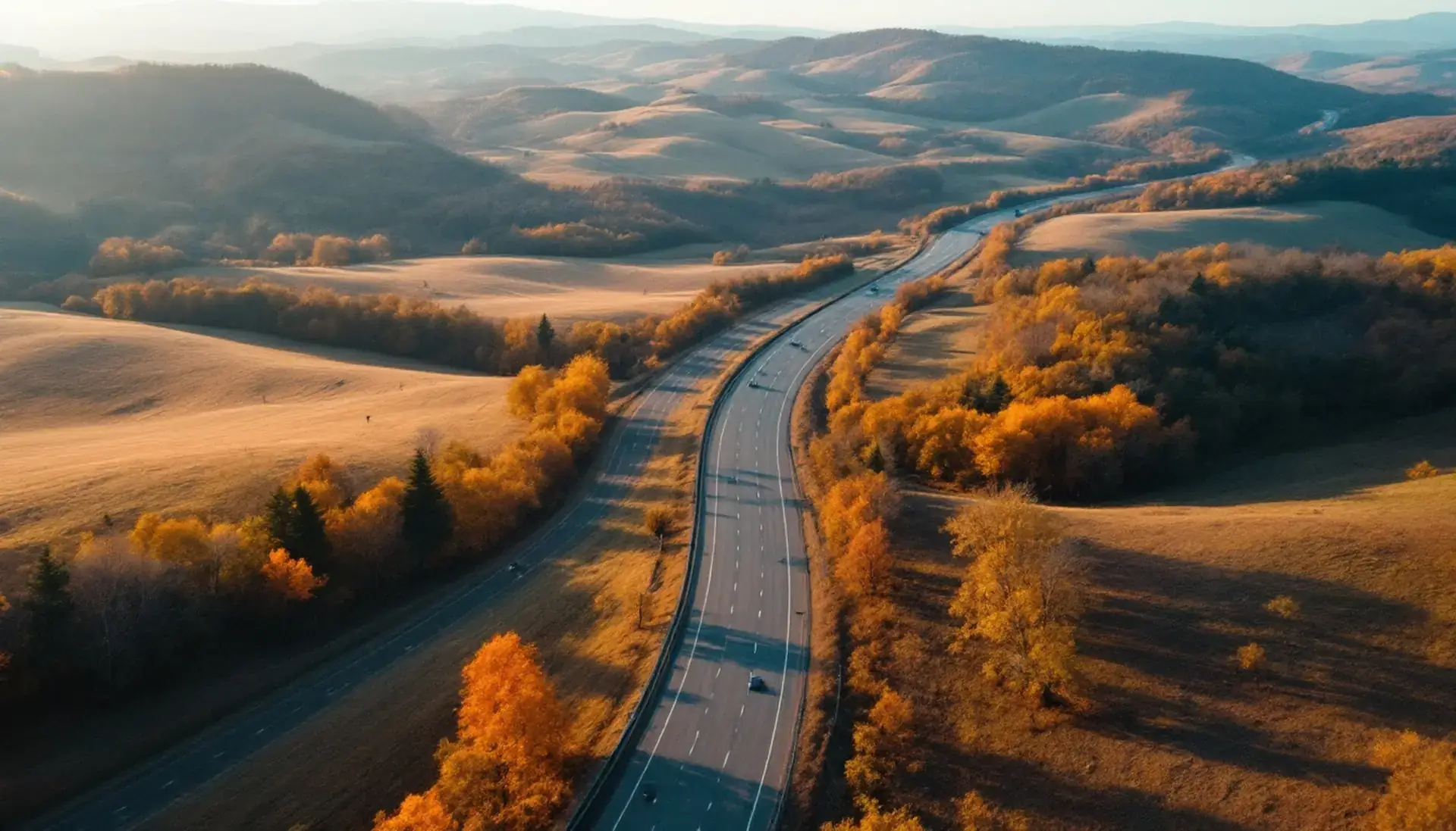 A highway curving through autumn hills